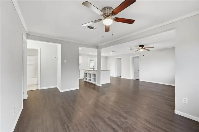 a view of empty room with wooden floor and ceiling fan
