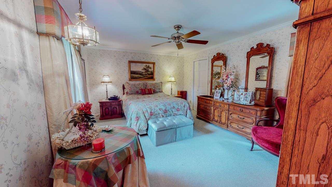 10 Canterbury Drive Roxboro, NC 27573 - Photo 16 of 30 a bedroom with furniture and a chandelier