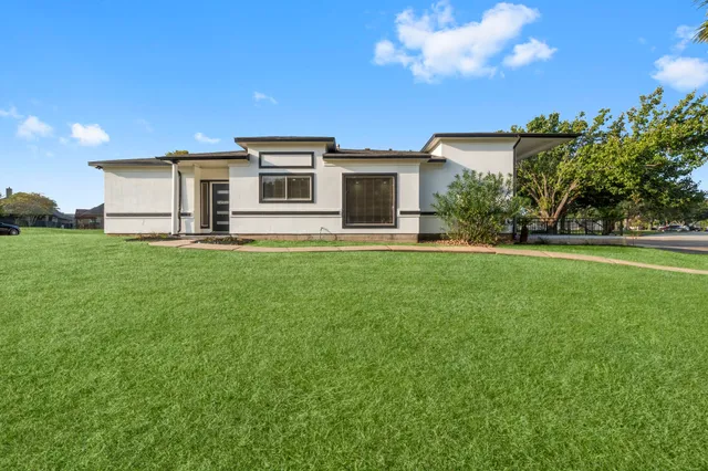 a front view of a house with a garden and yard