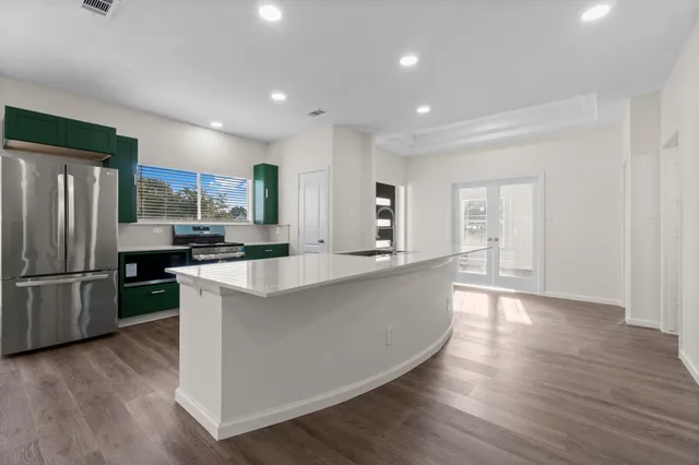a view of a room with wooden floor a ceiling fan and windows