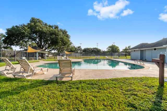 a view of a swimming pool with a yard and sitting area
