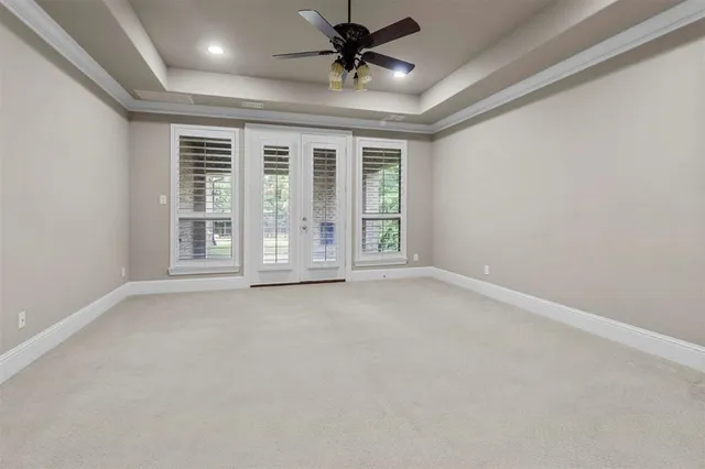 an empty room with windows and ceiling fan