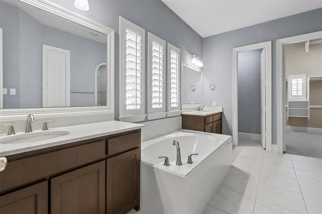 a spacious bathroom with a tub sink and mirror