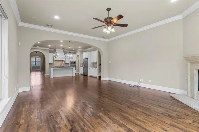 a view of a livingroom with wooden floor and a ceiling fan