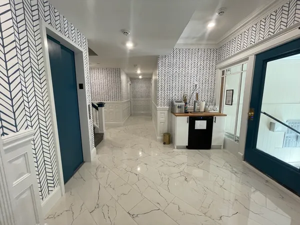 a view of a hallway with furniture and a window