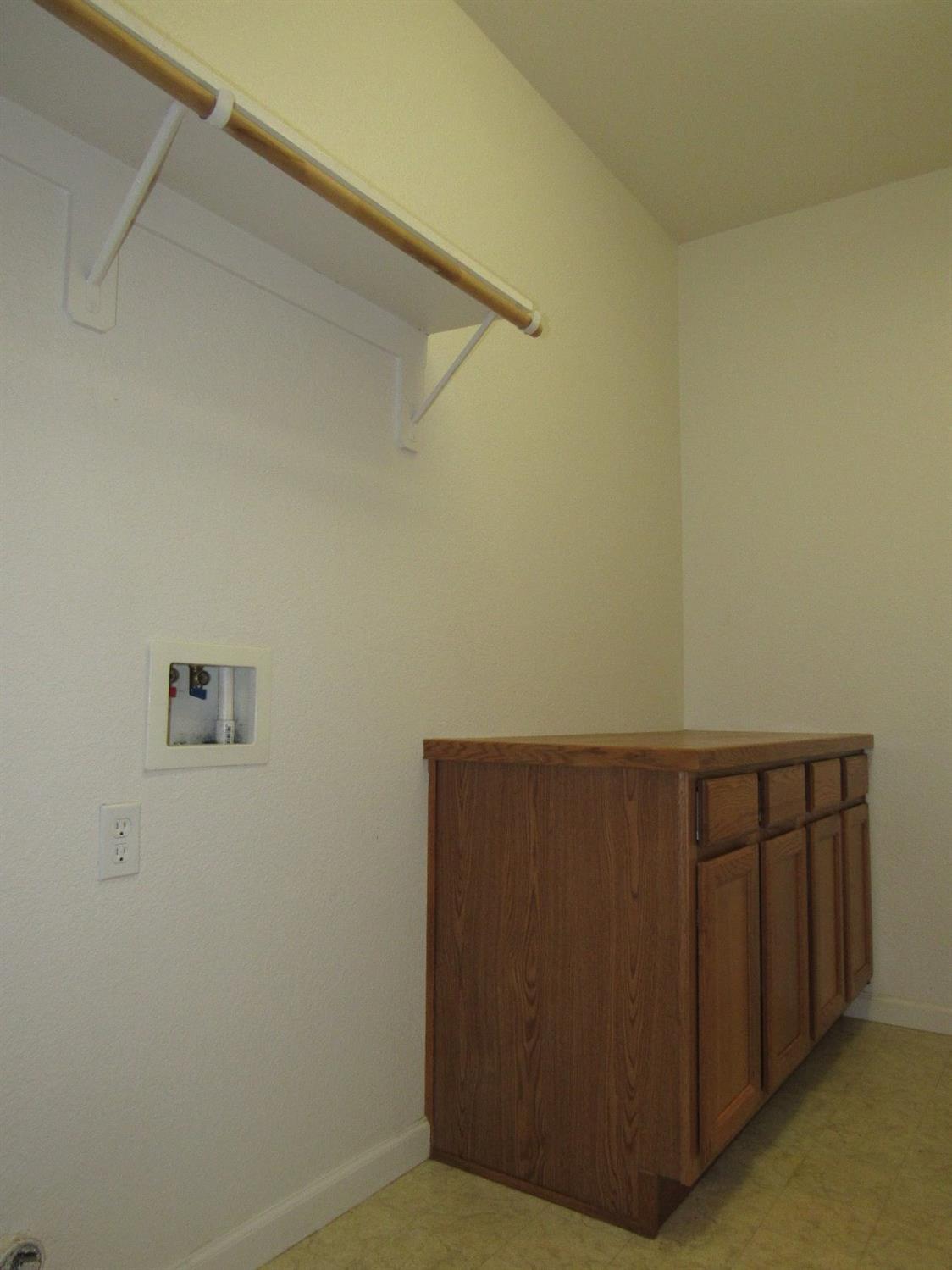 2141 Sheldon Court Reedley, CA 93654 - Photo 16 of 22 A large laundry room with a shelf and folding countertop. With built in cabinets to store linens and more.