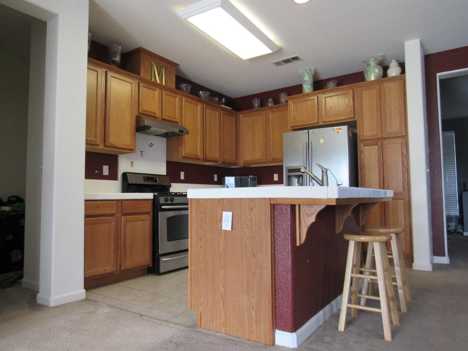 2141 Sheldon Court Reedley, CA 93654 - Photo 4 of 22 Kitchen island with a dishwasher, sink and filtered water dispenser.