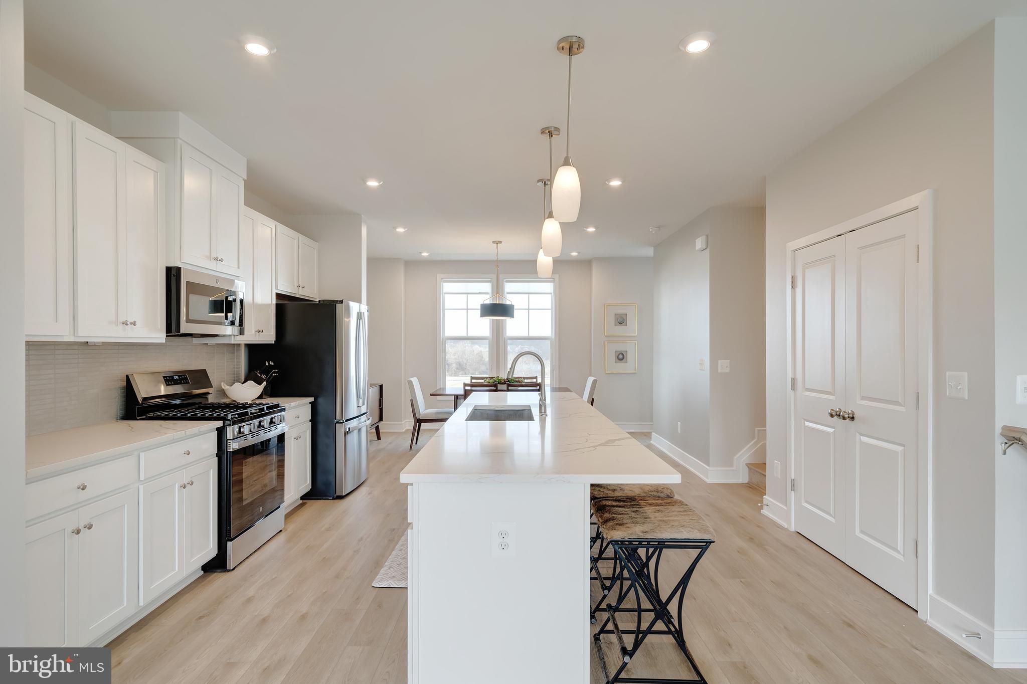 105 Checkerspot Way White Post, VA 22663 - Photo 15 of 37 a kitchen with stainless steel appliances kitchen island granite countertop a stove top oven a sink a refrigerator and white cabinets with wooden floor
