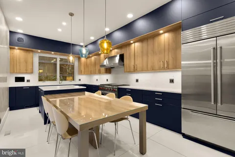 a kitchen with a table chairs refrigerator and microwave