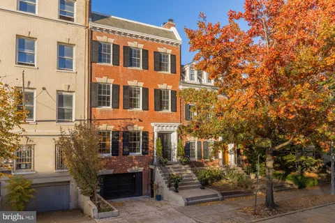 a front view of a house with a tree