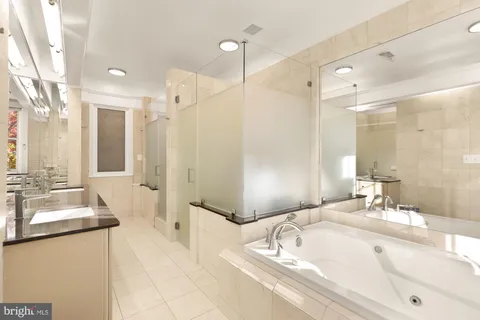 a bathroom with a tub sink and mirror
