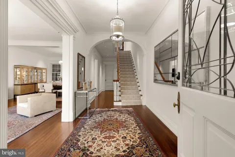 a hallway with white walls and chandelier