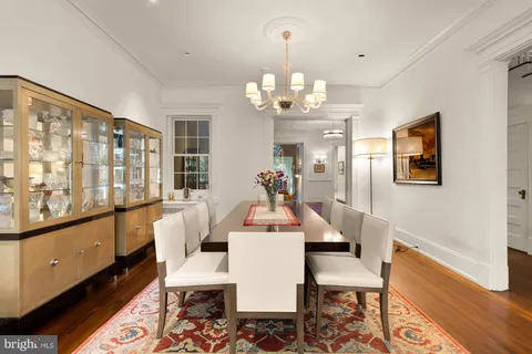 a view of a dining room with furniture a chandelier and wooden floor