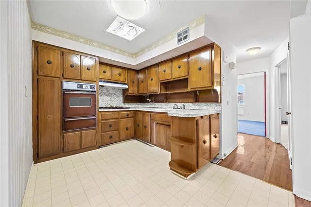 a kitchen with stainless steel appliances granite countertop a stove a sink and a refrigerator