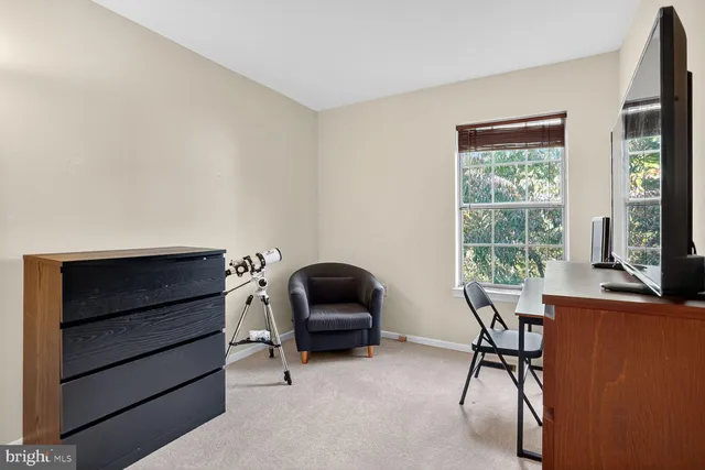 a view of a workspace with furniture and a window