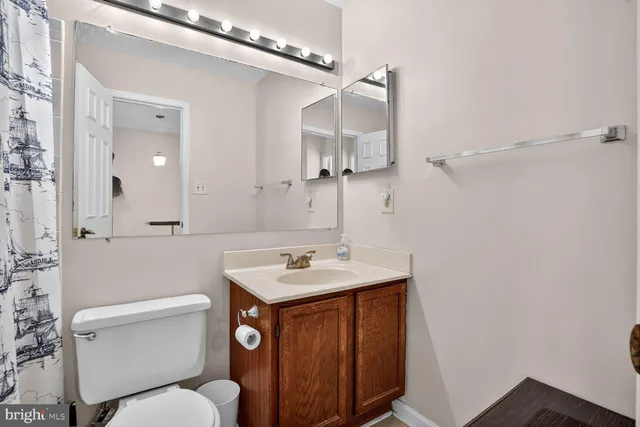 a bathroom with a sink toilet vanity and shower