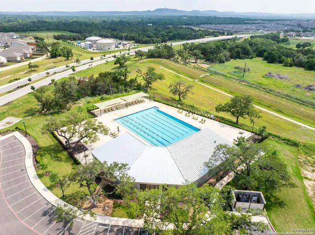 a view of a swimming pool with a patio and a garden