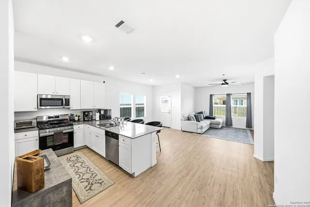 a kitchen with granite countertop a sink a stove and cabinets