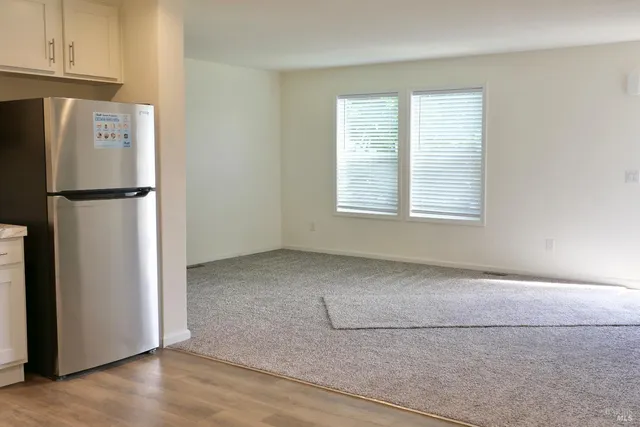 a view of kitchen with refrigerator and window