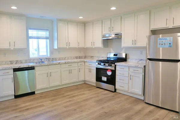 a kitchen with stainless steel appliances granite countertop a refrigerator sink and cabinets