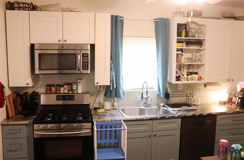 201 Shaffner Street Ponder, TX 76259 - Photo 12 of 40 a kitchen with stainless steel appliances a stove a sink and a microwave