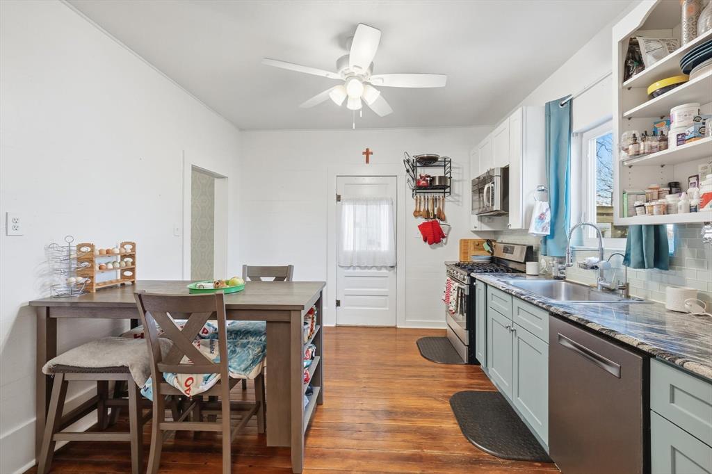 201 Shaffner Street Ponder, TX 76259 - Photo 18 of 40 a kitchen with stainless steel appliances granite countertop a dining table chairs stove a sink and dishwasher