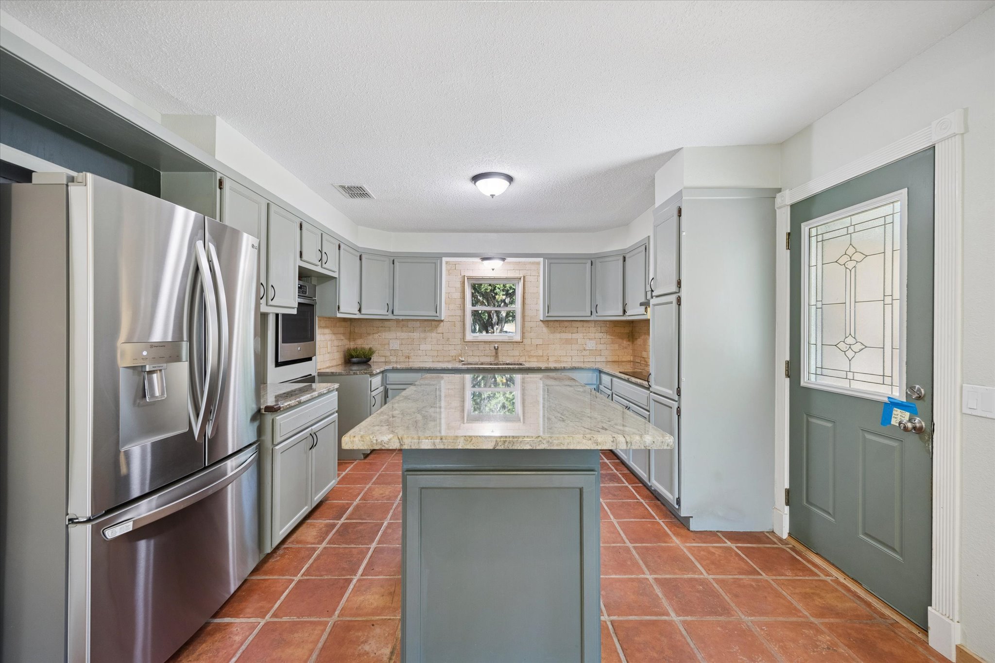 1091 Alta Vista Road Spicewood, TX 78669 - Photo 19 of 28 a kitchen with stainless steel appliances granite countertop a refrigerator and a sink