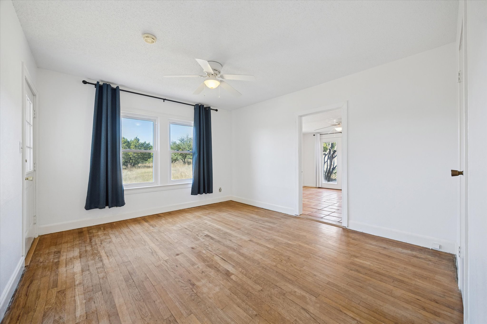 1091 Alta Vista Road Spicewood, TX 78669 - Photo 24 of 28 a view of an empty room with wooden floor and a window