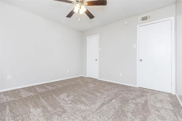 an empty room with a chandelier fan