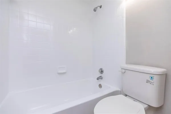 a white toilet sitting next to a bath tub