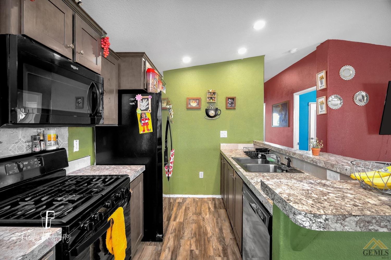 Undisclosed Address Bakersfield, CA 93308 - Photo 13 of 32 a kitchen with stainless steel appliances granite countertop a stove a sink and a microwave