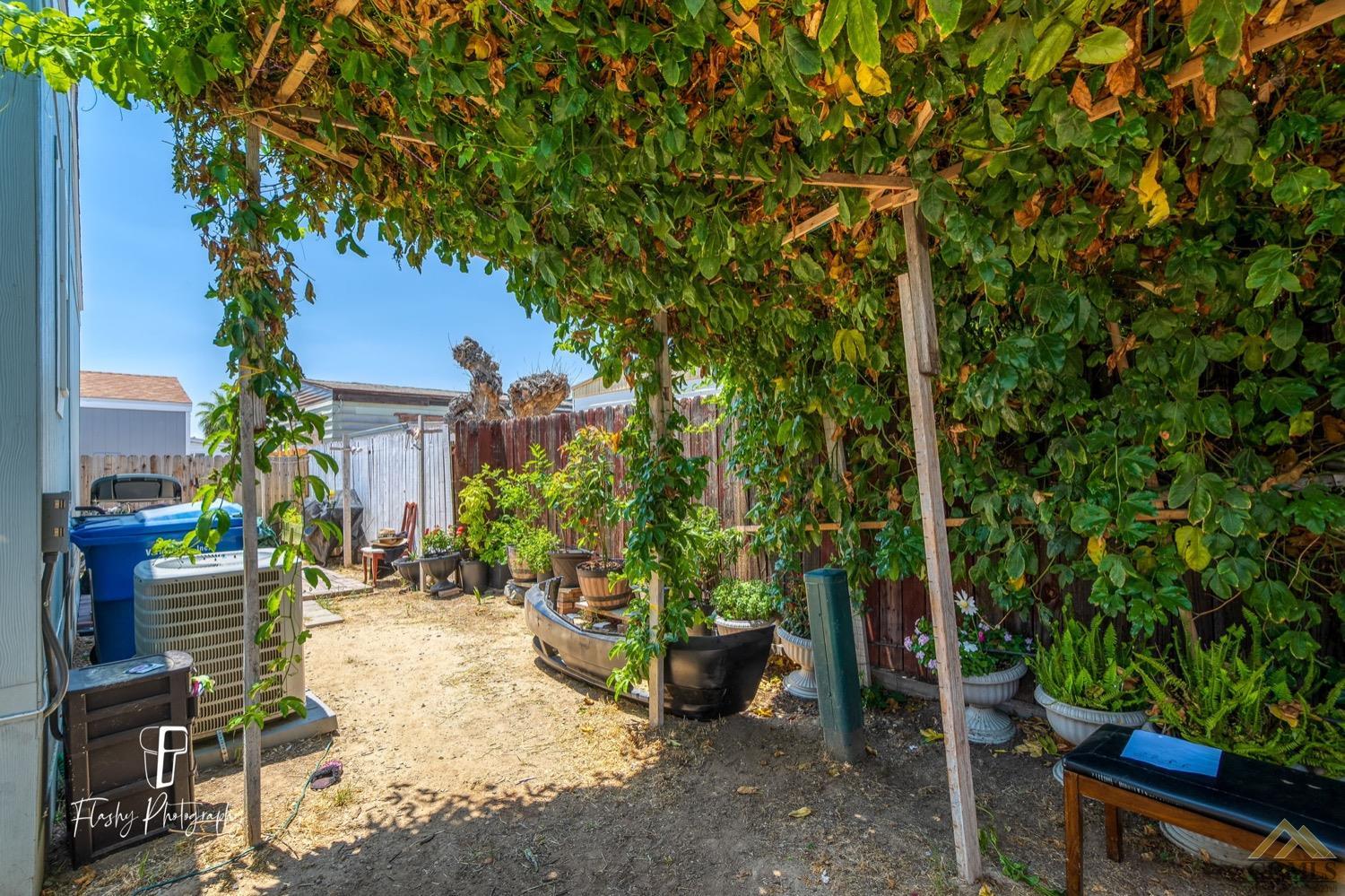 Undisclosed Address Bakersfield, CA 93308 - Photo 30 of 32 a view of a patio with table and chairs potted plants and large tree