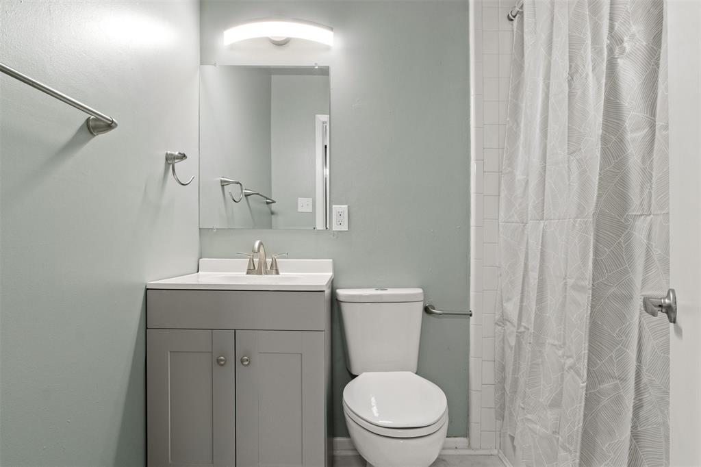 1804 Gould Street, Unit 3 Dallas, TX 75215 - Photo 12 of 19 a bathroom with a toilet a sink a vanity and mirror