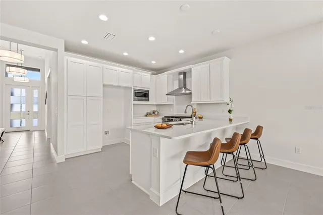 a kitchen with stainless steel appliances a white table and chairs in it