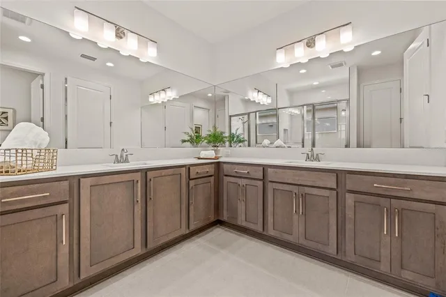 a spacious bathroom with a double vanity sink and a mirror