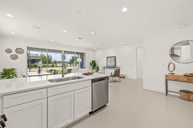 a kitchen with sink and view of living room