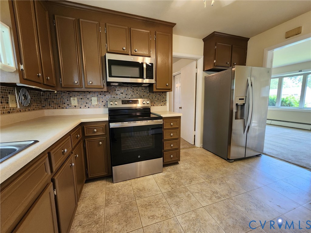 4704 Greenleigh Road Richmond, VA 23223 - Photo 4 of 7 a kitchen with stainless steel appliances granite countertop a refrigerator stove and microwave