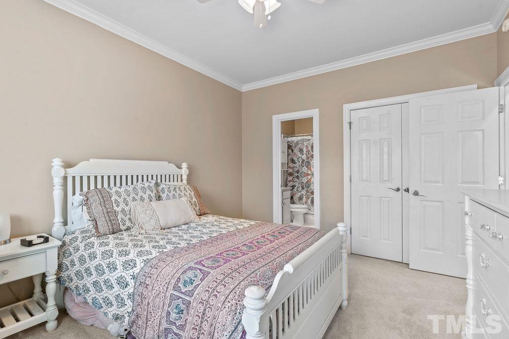 1303 Cameron View Court Raleigh, NC 27608 - Photo 14 of 30 a bedroom with a bed and a chandelier