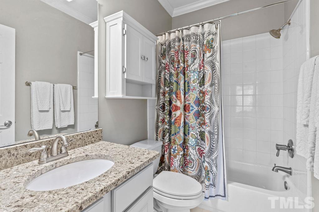 1303 Cameron View Court Raleigh, NC 27608 - Photo 16 of 30 a bathroom with a granite countertop toilet a sink a mirror a shower curtain and a bath tub