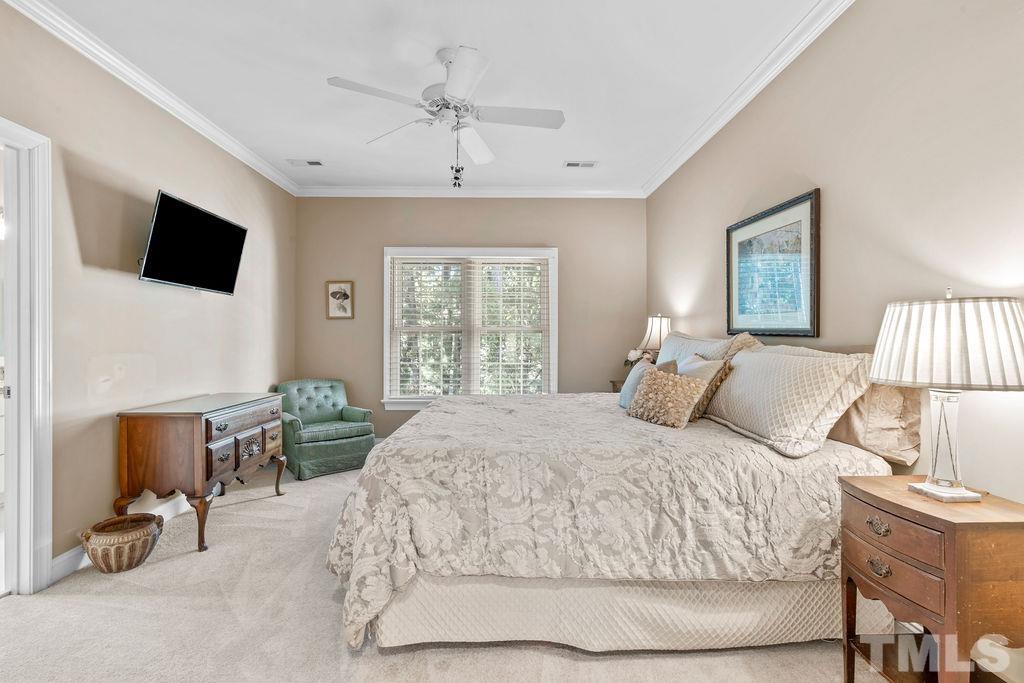 1303 Cameron View Court Raleigh, NC 27608 - Photo 17 of 30 a bedroom with a bed a couch and a flat tv screen