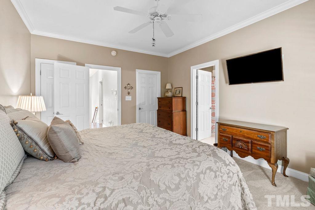 1303 Cameron View Court Raleigh, NC 27608 - Photo 19 of 30 a spacious bedroom with a bed and a flat screen tv