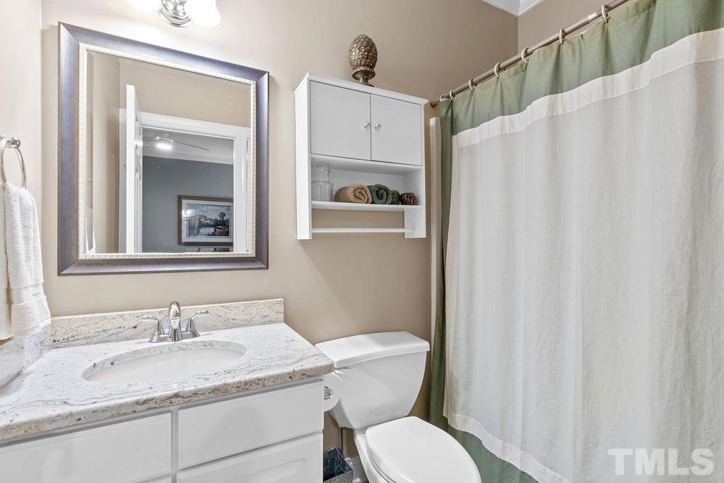 1303 Cameron View Court Raleigh, NC 27608 - Photo 25 of 30 a bathroom with a granite countertop sink vanity mirror and toilet