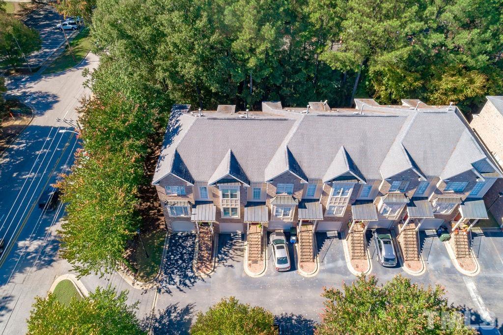 1303 Cameron View Court Raleigh, NC 27608 - Photo 29 of 30 an aerial view of a residential apartment building with a yard and parking spaces