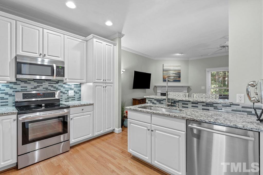 1303 Cameron View Court Raleigh, NC 27608 - Photo 6 of 30 a kitchen with a sink stove and microwave