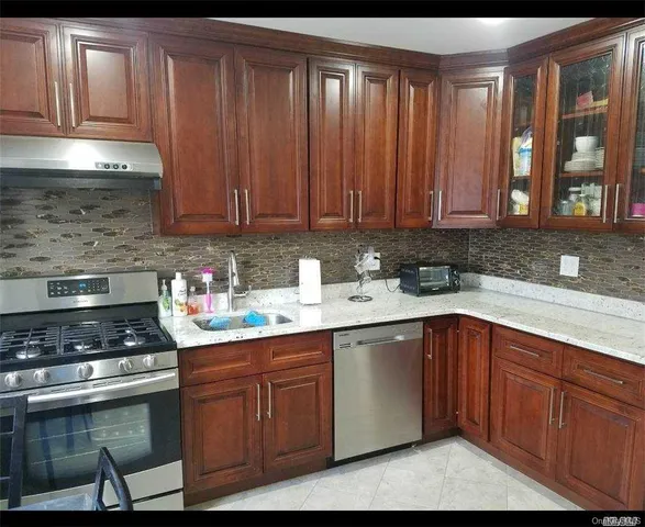 a kitchen with granite countertop wooden cabinets a sink and dishwasher