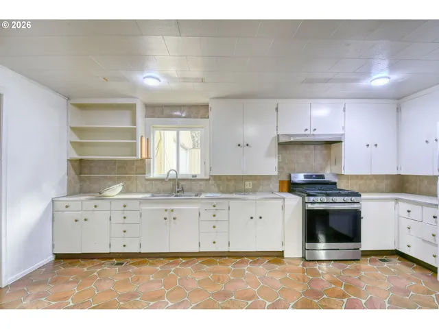 a kitchen with granite countertop a stove sink and cabinets