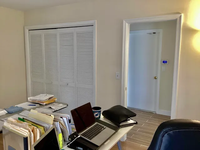 a bed and a computer on a desk