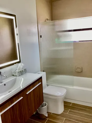 a bathroom with a sink a toilet and shower