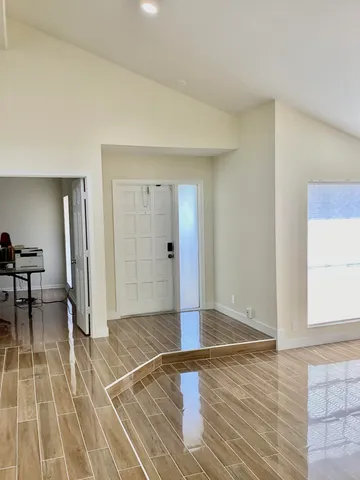 an empty room with wooden floor and a rug