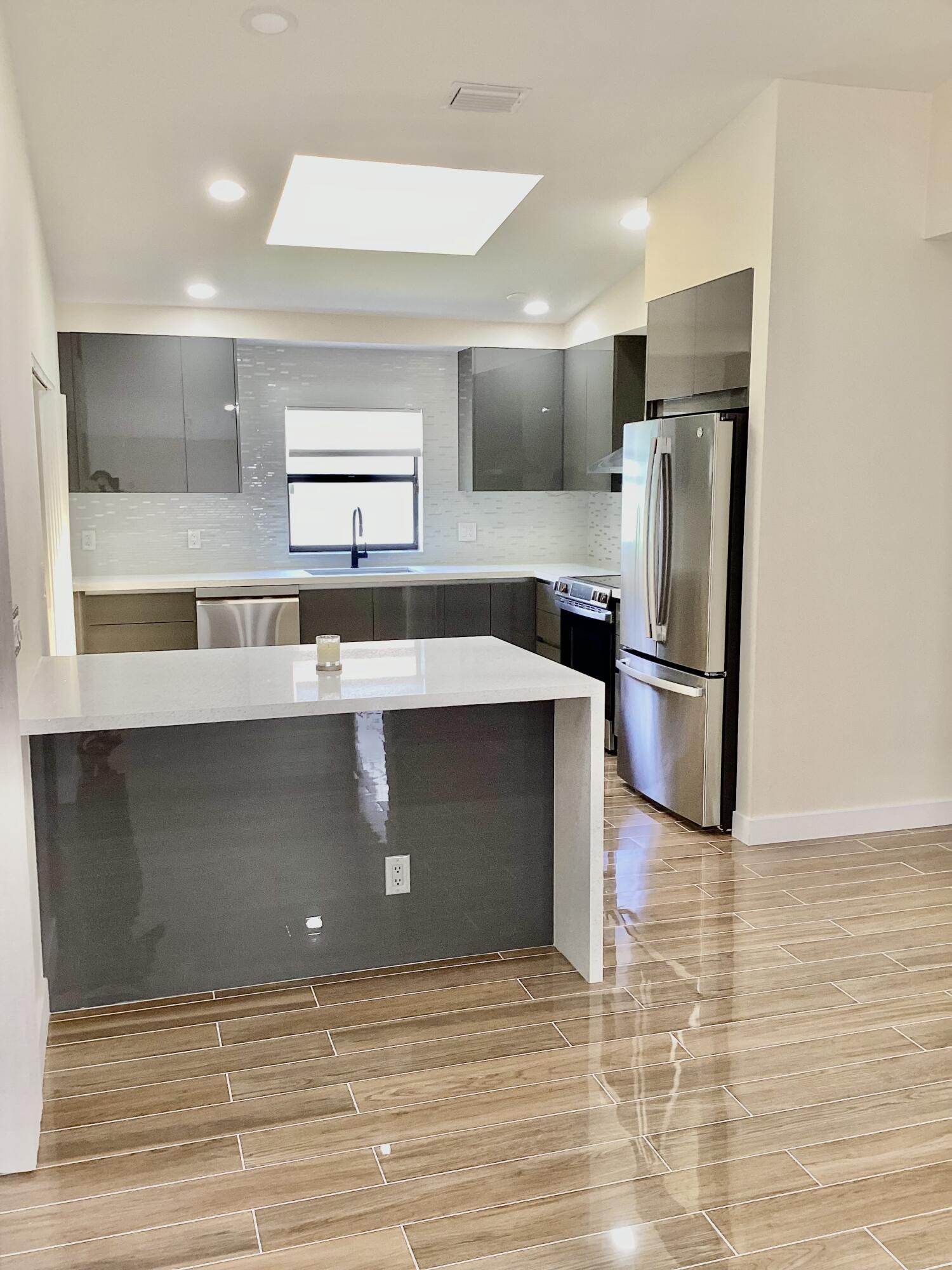 8895 Old Pine Road, Unit 4 Boca Raton, FL 33433 - Photo 8 of 46 a kitchen with kitchen island a counter top space cabinets and stainless steel appliances